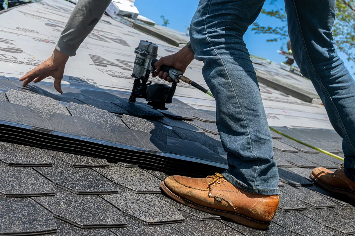 roofer nailing asphalt shingles